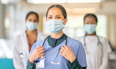 Three healthcare professionals wearing masks and scrubs stand together, symbolizing hospital efficiency and patient safety.