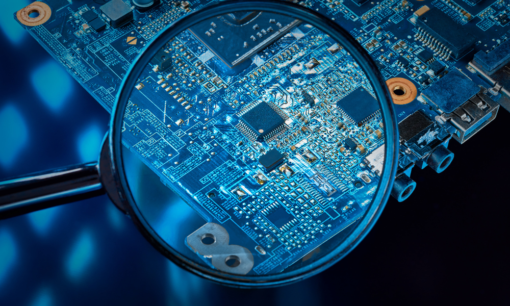 A close-up of a circuit board under a magnifying glass, highlighting the detail in the tech debate of MediaTek vs Snapdragon.
