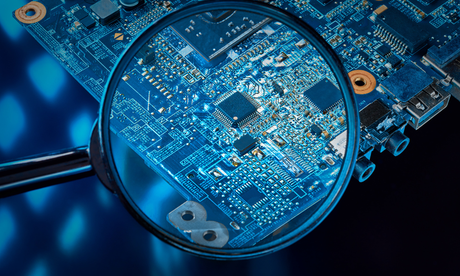 A close-up of a circuit board under a magnifying glass, highlighting the detail in the tech debate of MediaTek vs Snapdragon.
